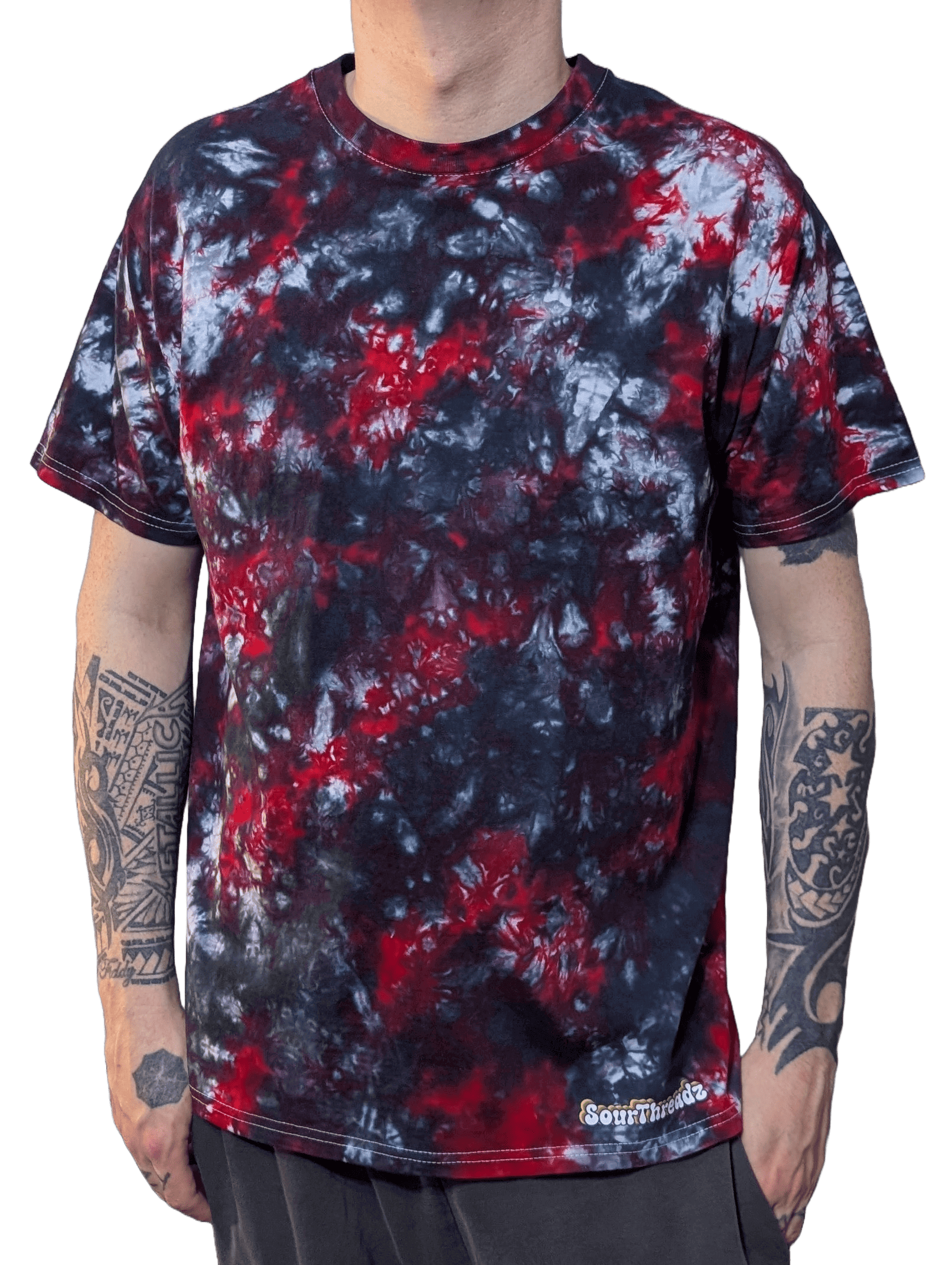 Person wearing a tie-dye t-shirt with red, black, and white patterns on a plain background